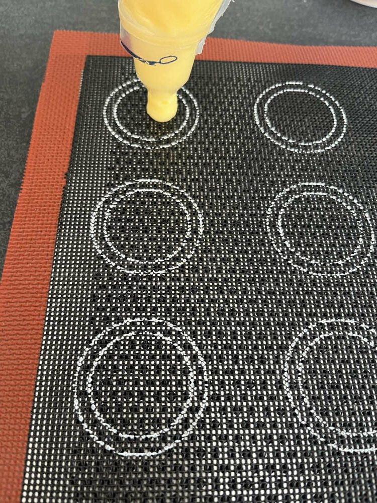 Kleine Kugeln auf ein Backblech oder auf eine perforierte Silikon Backmatte spritzen