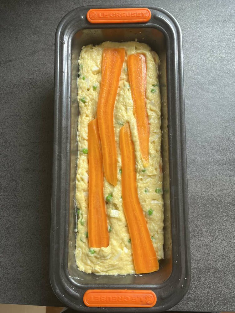 Der restliche Teig und die übriggebliebenen Möhren kommen in die Form