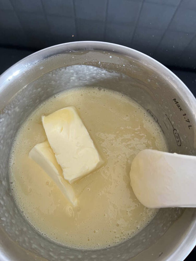 Die Butter in der heißen Creme zergehen lassen und verrühren