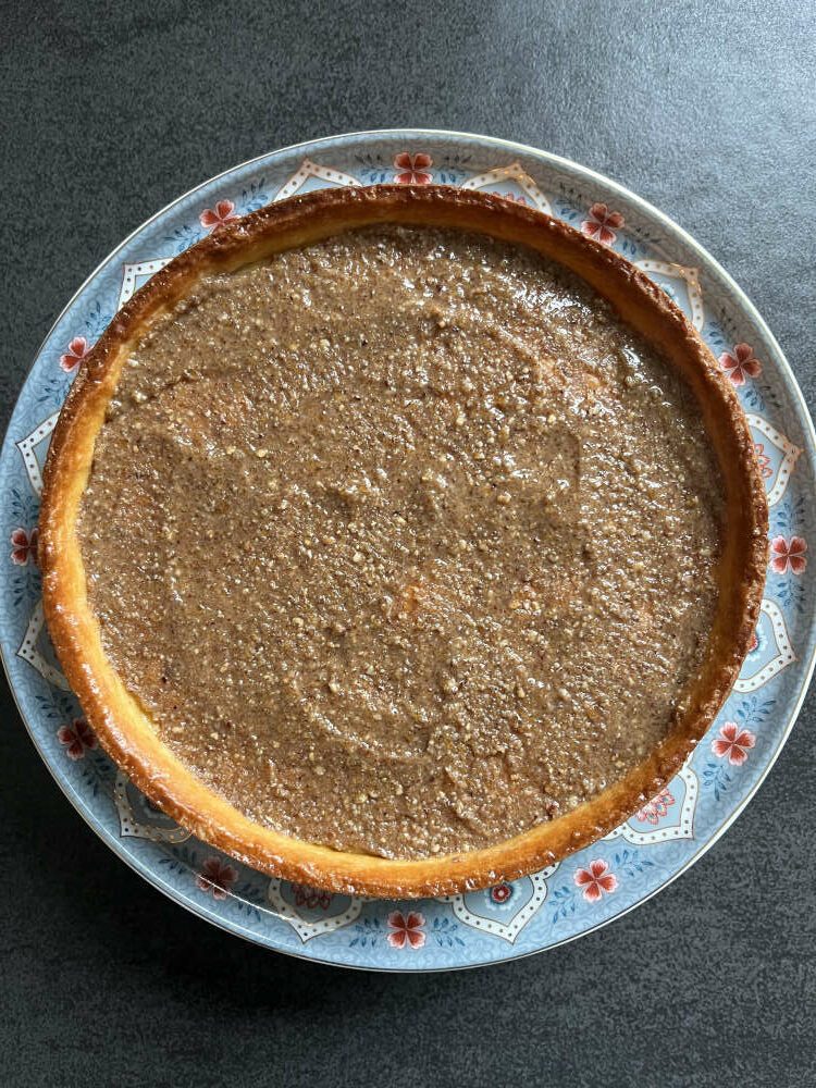 Eine dünne Schicht Praliné auf dem Tarteboden verteilen