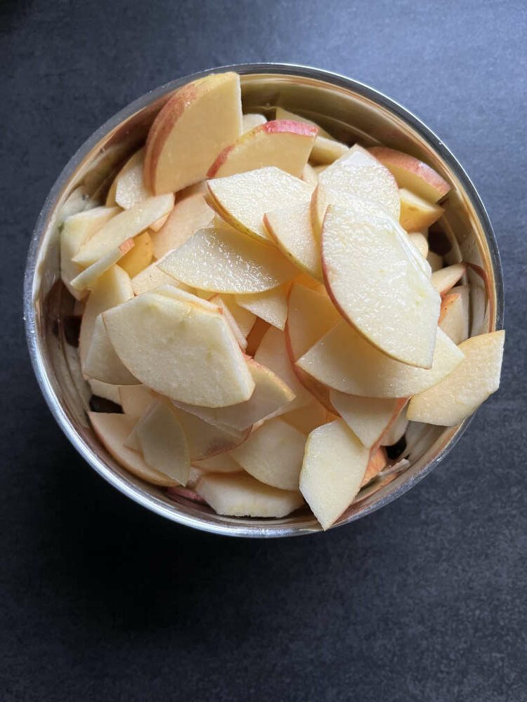 Die Äpfel in dünne Scheiben schneiden und mit dem Zitronensaft beträufeln