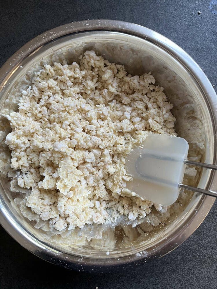 Reiswaffeln und Kokosraspeln mit der weißen Kuvertüre vermischen