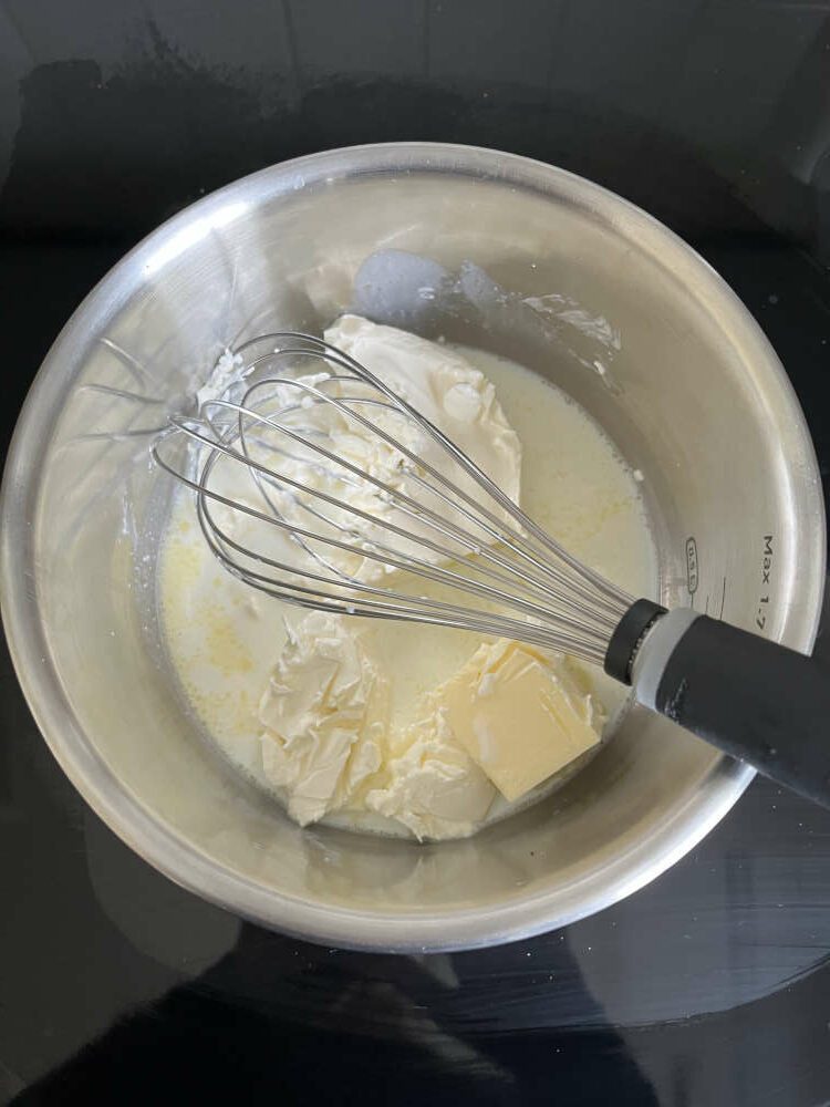 Philadelphia Frischkäse, Butter und Milch in einem Topf lauwarm erhitzen