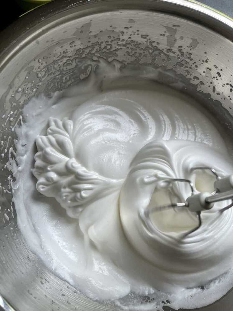 Das Eiweiß weiter schlagen, bis ein weißer fester Schaum entsteht. Den restlichen Zucker dazugeben und weiter schlagen