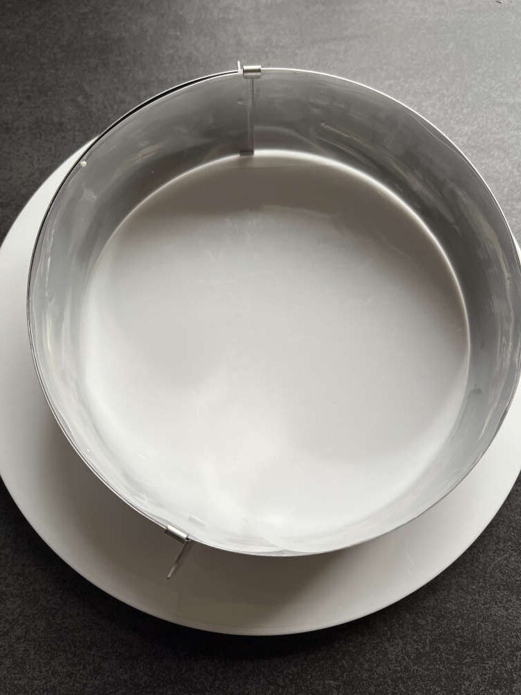 Einen 20 cm großen Tortenring mit Tortenrandfolie auslegen