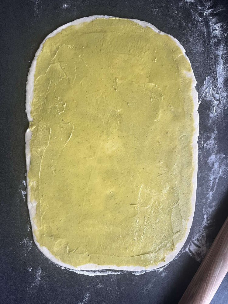 Die Pistaziencreme auf dem Teig verstreichen