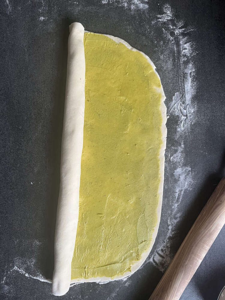 Den Teig von der Längsseite her aufrollen