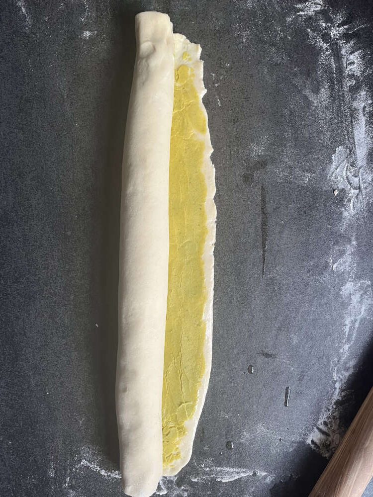 Den äußeren freien Rand vor dem Schließen der Rolle noch mit Wasser benetzen, dann klebt der Rand besser