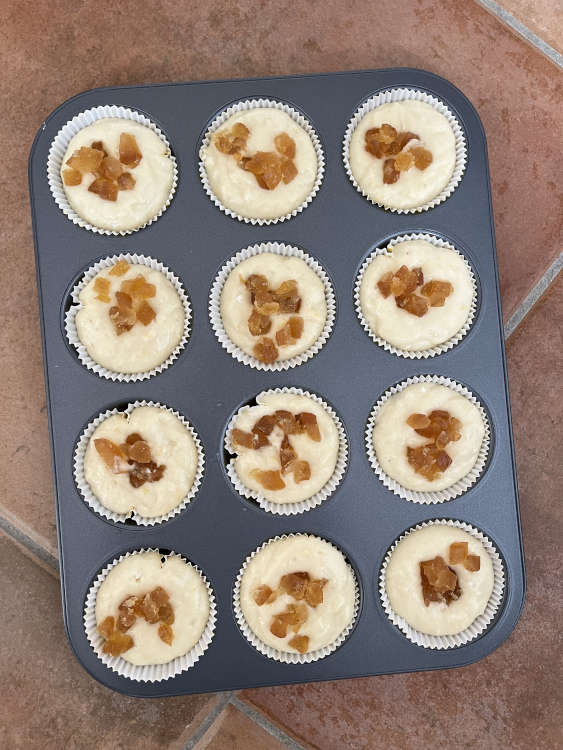 Vor dem Backen die Muffins mit den kandierten Zitronenstückchen garnieren