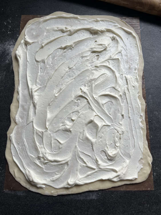 Creme fraîche und Magerquark verrühren und auf dem Teig verstreichen