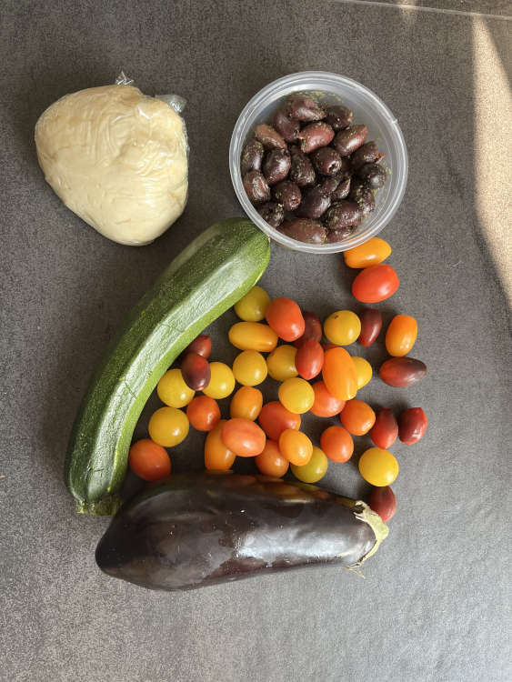 Zucchini, Aubergine, Tomaten und Oliven für den Belag
