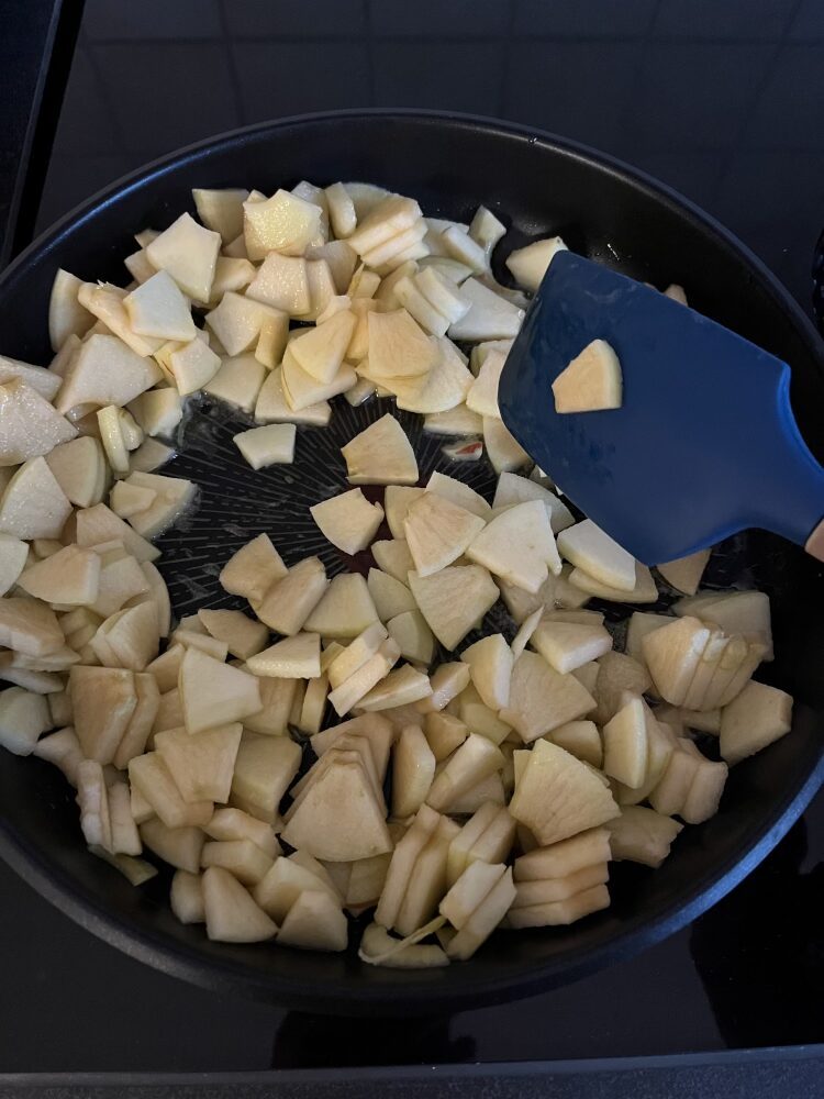 Die Apfelspalten in einer Pfanne zusammen mit der Butter andünsten